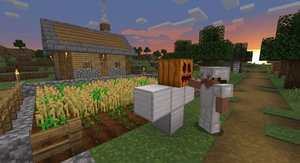 Player building an iron golem by placing a carved pumpkin on iron blocks near a farm at sunset